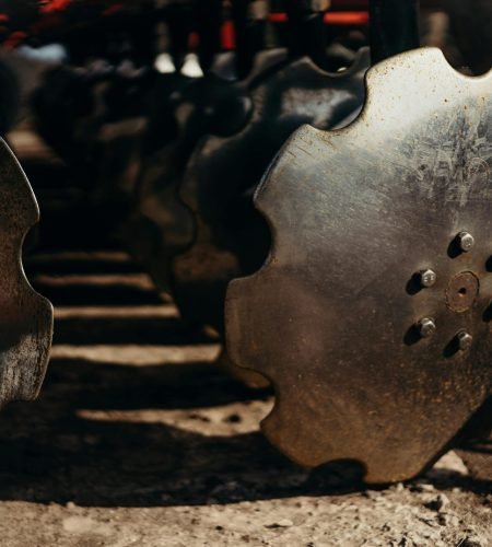 Detailed view of metallic plow discs, showcasing texture and design in natural light.